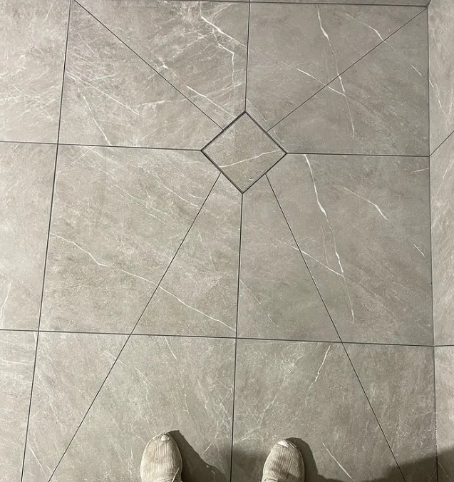 Klinkergolv med diagonala skärningar som möter en kvadratisk golvbrunn