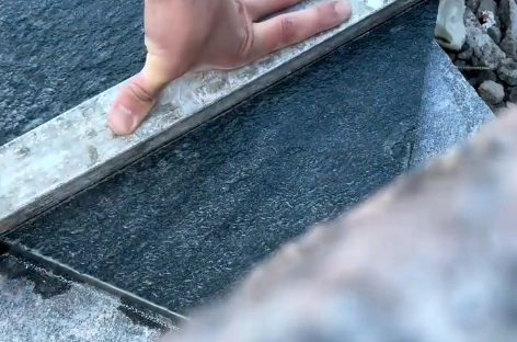 Kontroll av fog och nivå mellan mörka granithällar under läggning utomhus